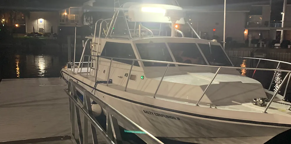 The Salty Confusion II at the dock at night with her deck lights on